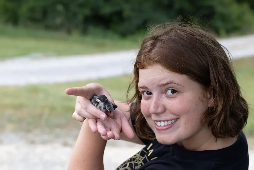A young woman holding a treefrog